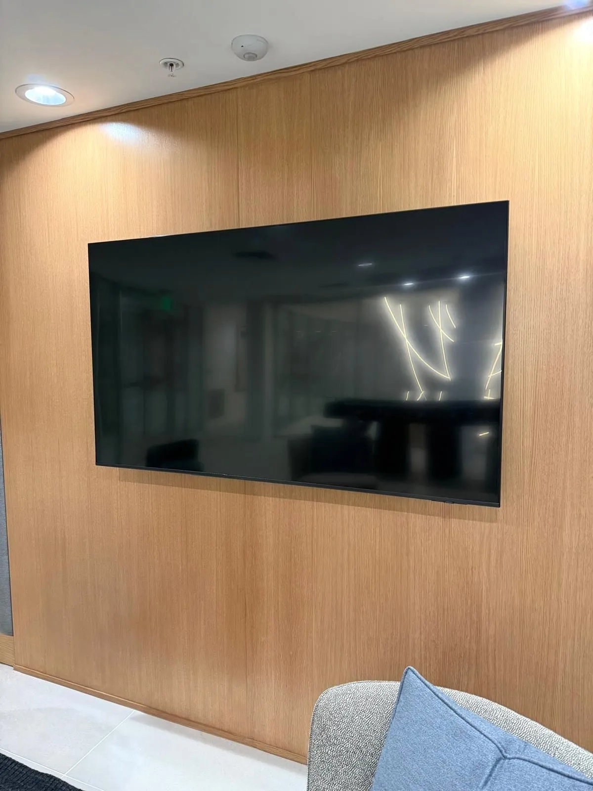 TV mounted at seated eye level on an oak-panelled feature wall